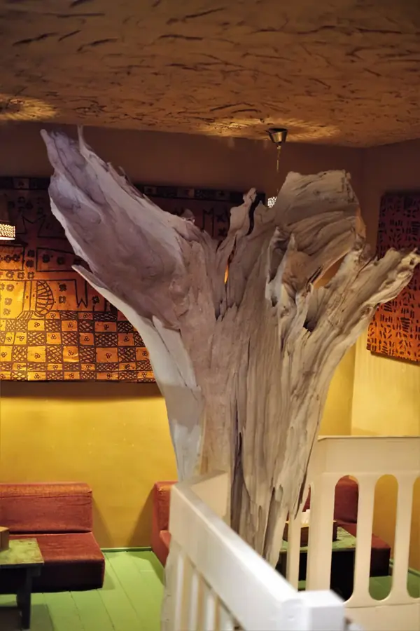 Holzskulptur vor einer gemusterten Wand
