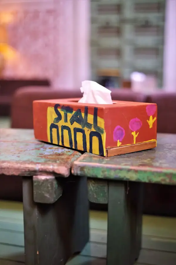 Bemalte Taschentuchbox mit der Aufschrift „Stall“ auf einem alten Holztisch