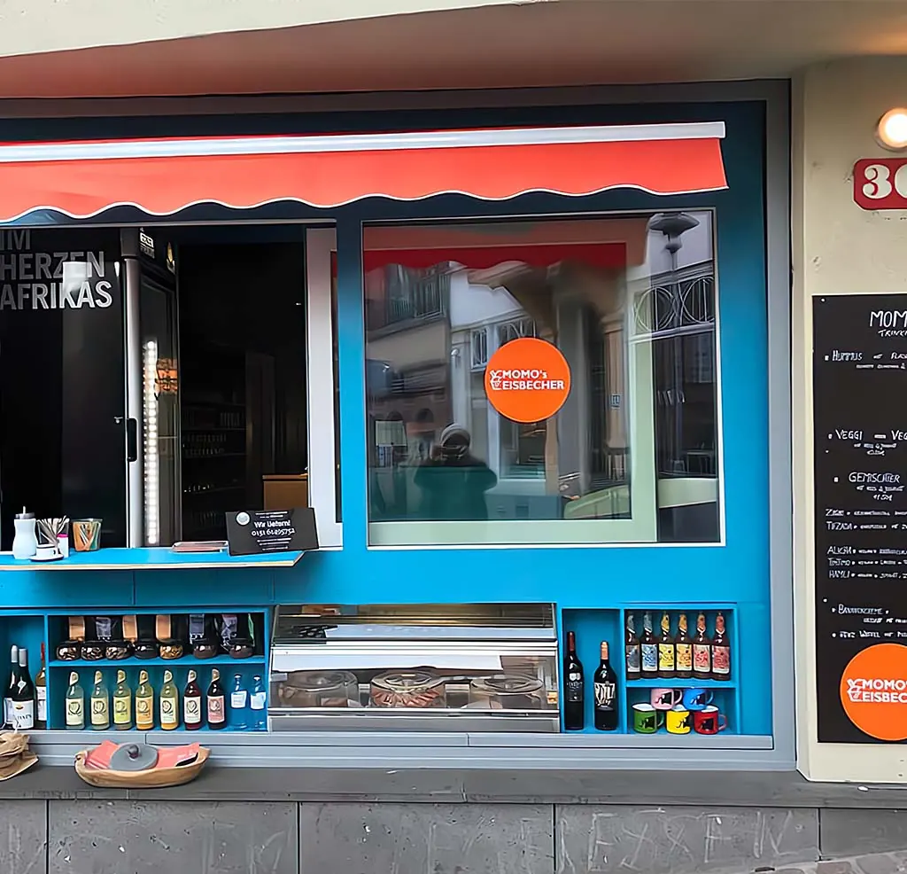 Blaues Verkaufsfenster mit orangem Sonnendach, Flaschen in den Regalen darunter