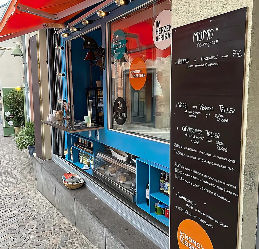 Kreidetafel von Momo’s Trinkhalle neben dem Verkaufsfenster